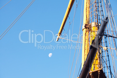 mast ship and the moon against the blue sky