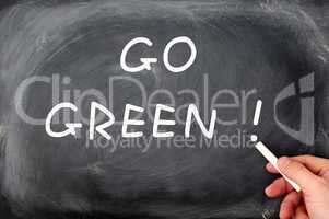 "Go Green" written on a smudged chalkboard background