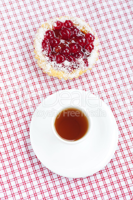 beautiful cake with berries and tea on plaid fabric