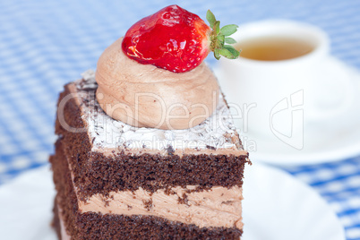 beautiful cake with strawberry and tea on plaid fabric