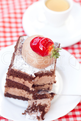 beautiful cake with strawberry and tea on plaid fabric