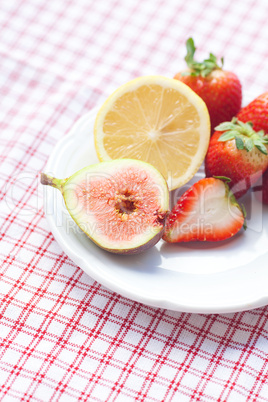 lemon, fig and strawberries on a plate