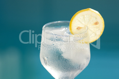 Swimming pool and a wine glass with ice and with lemon
