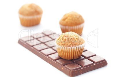 bar of dark chocolate and muffin isolated on white