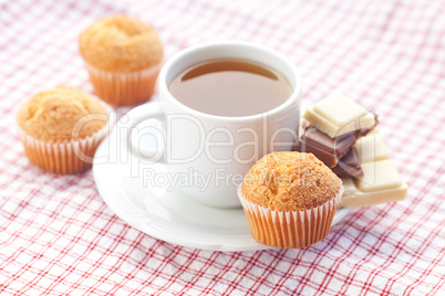 bar of chocolate,tea and muffin on plaid fabric