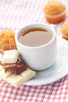 bar of chocolate,tea and muffin on plaid fabric