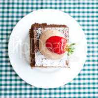 beautiful cake with strawberry on plaid fabric