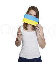 Attractive woman hides her face behind flag of Ukraine in front of white background