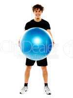 Male fitness trainer holding a pilate ball