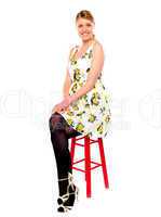 Glamourous woman sitting on stool