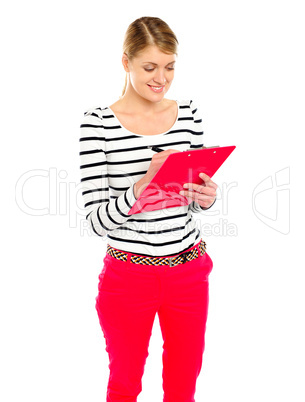 Young girl writing makes notes on clipboard