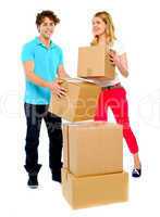 A young couple holds boxes in studio