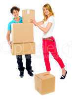Young couple holding and moving boxes