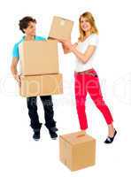 Smiling couple moving cardboard boxes