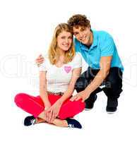 Teenage couple sitting on floor, studio shot