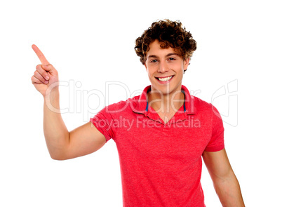 Handsome young teenager in casuals pointing away