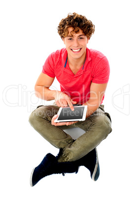 Smiling young guy using his tablet pc