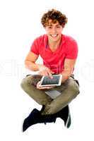 Smiling young guy using his tablet pc