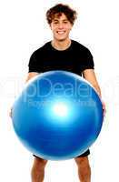 Man in sportswear holding big ball