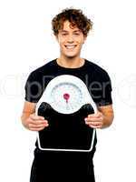 Attractive athlete showing weighing scale