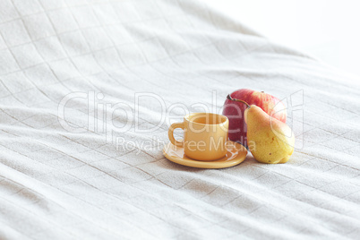 cup of tea,apple and pear on the bed