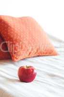apple on the bed with two pillows