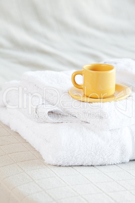 cup lying on towels on the bed