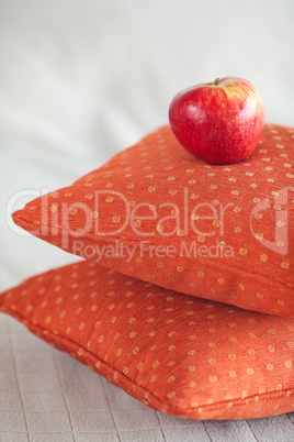 apple lying on pillows on the bed