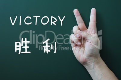 Victory gesture on a blackboard background