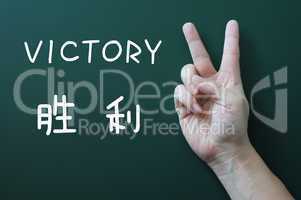 Victory gesture on a blackboard background