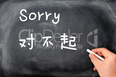 "Sorry" written on a blackboard background with a Chinese version
