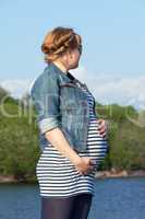 Pregnant woman on the river coast
