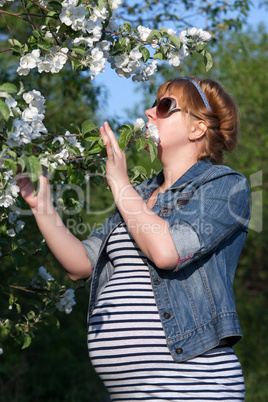 pregnant woman touching flower