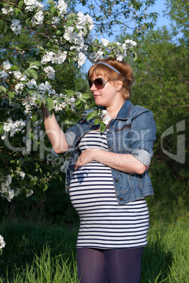 Pregnant woman touching flower