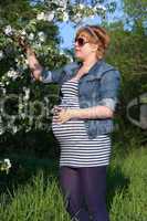 Pregnant woman touching flower