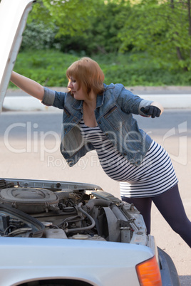 Pregnant Woman Opens the Hood of the Car