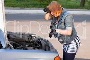 Pregnant Woman Trying to Repair the Car