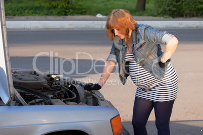 Pregnant Woman Trying to Repair the Car