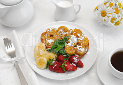 French toast with syrup and a banana with powdered sugar