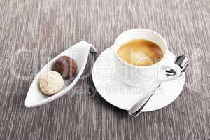 Tasse Kaffee mit einer Auswahl an Pralinen aus Schokolade