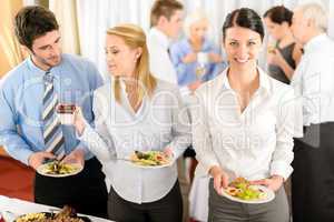Business colleagues serve themselves at buffet