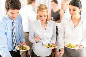 Business colleagues serve themselves at buffet