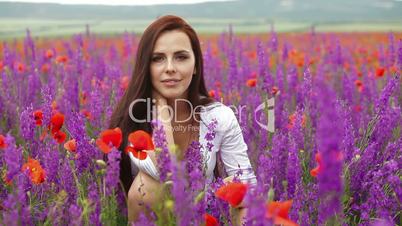 Attractive young woman in blossoming field