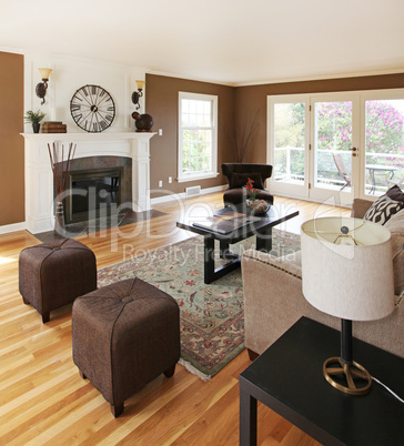 Brown livinng room with white fireplace and luxury furniture.