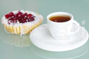 beautiful cake with berries and tea on glass table