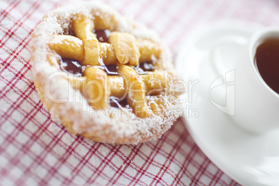 beautiful cake with berries and tea on plaid fabric