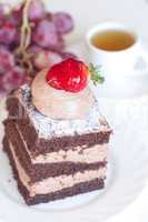 beautiful cake with strawberry,grapes and tea on a white backgro