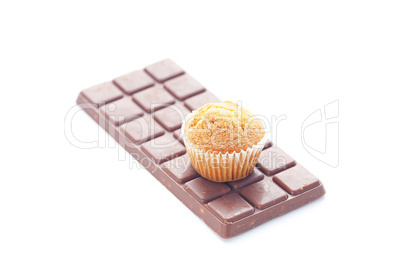 bar of dark chocolate and muffin isolated on white