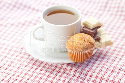 bar of chocolate,tea and muffin on plaid fabric