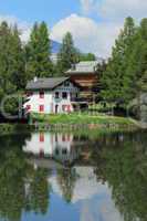House and white lake at Crans Montana, by summer